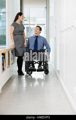 Ufficio disabili lavoratore con un collega Foto Stock