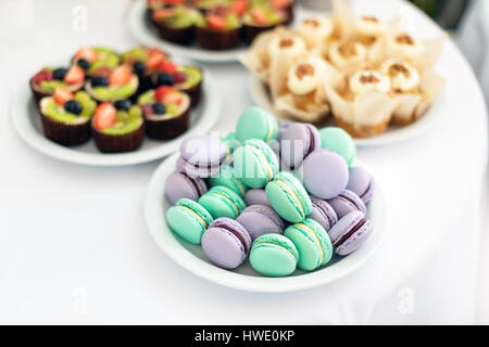 Turchese e viola macarons. Torte nuziali sul tavolo. Dolci. Messa a fuoco selettiva Foto Stock