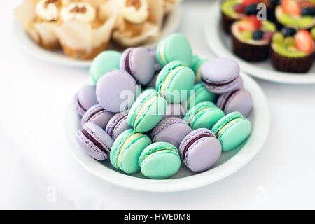 Turchese e viola macarons. Torte nuziali sul tavolo. Dolci. Messa a fuoco selettiva Foto Stock