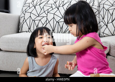 Asian poco ragazze cinesi di mangiare la pizza a casa Foto Stock