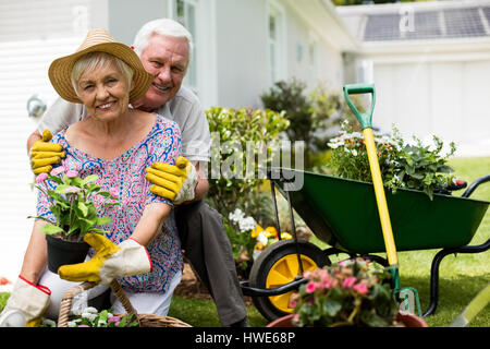 Ritratto di coppia senior che abbraccia ogni altra in cortile Foto Stock