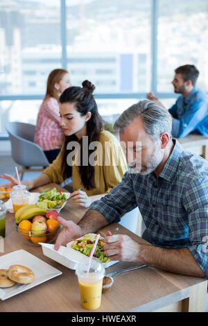 Creative team aziendale avente pasto in ufficio Foto Stock