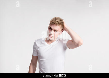 Giovane bello hipster uomo in bianco t-shirt, studio shot. Foto Stock