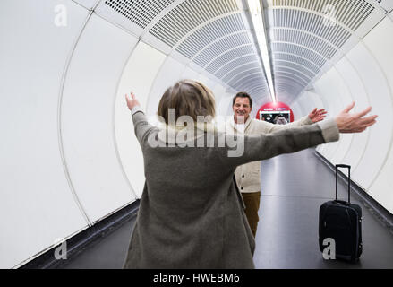 Coppia senior nel corridoio della metropolitana tirando trolley. Foto Stock