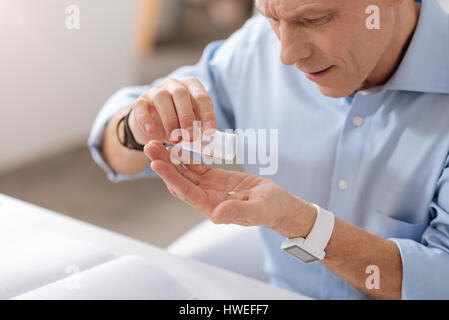 Close up foto di grave uomo riversando fuori compresse Foto Stock