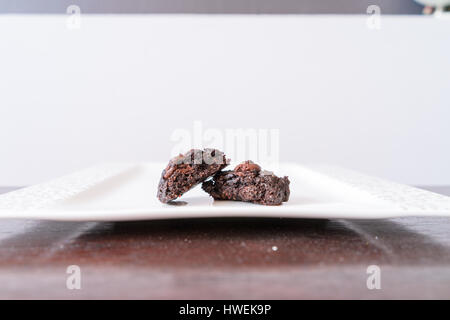 Sezione trasversale del vegan brownie al cioccolato cookie sul tavolo in legno e piastra bianca Foto Stock
