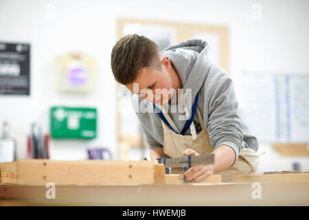 Un adolescente di sesso maschile di falegnameria di regolazione dello studente morsetto di legno nel collegio di officina Foto Stock