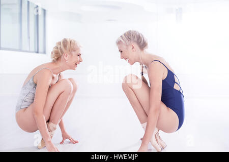 Due femmina ballerini la pratica in studio di danza, accovacciato di fronte a ogni altro Foto Stock