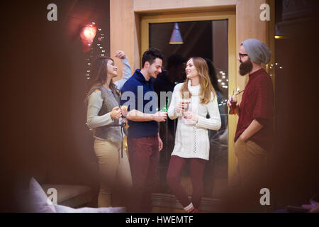 Gli amici sorseggiando un vin brulé in chalet Foto Stock