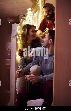 Gli amici sorseggiando un vin brulé in chalet Foto Stock