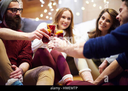 Gli amici sorseggiando un vin brulé in chalet Foto Stock