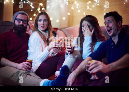 Gli amici sorseggiando un vin brulé in chalet Foto Stock