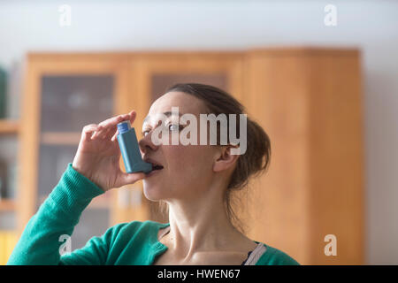 Donna che utilizza l'asma inalatore Foto Stock