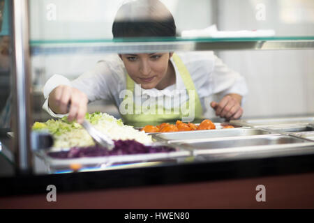 Giovane donna alla preparazione del cibo in un fast food shop Foto Stock