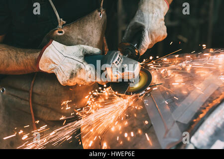 Mani di metallurgo macinazione di rame in forge workshop Foto Stock