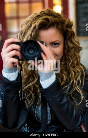 Donna che utilizza una fotocamera digitale Foto Stock