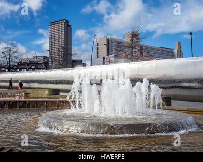 Fontana e il bordo di taglio di una scultura in un covone quadrato con hallam Univesity dietro Sheffield South Yorkshire Inghilterra Foto Stock