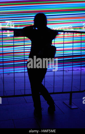 Una ragazza che fissa in strisce di luci durante la luce mi Marina Bay Festival in Singapore. Foto Stock