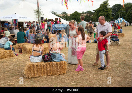 Famiglie godendo il sole estivo nella parte anteriore del cibo e delle bevande si spegne al porto Eliot Festival Cornovaglia Foto Stock