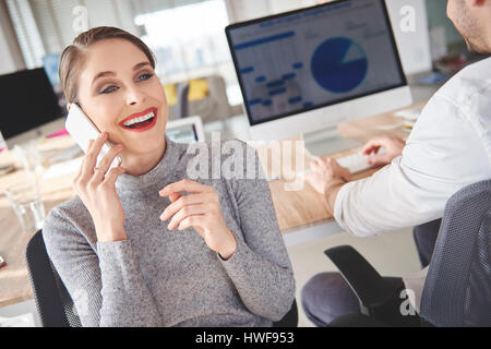 Donna prenotazione incontri con i clienti tramite il telefono Foto Stock