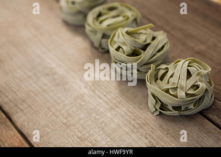 Tagliatelle disposti in una fila sullo sfondo di legno Foto Stock