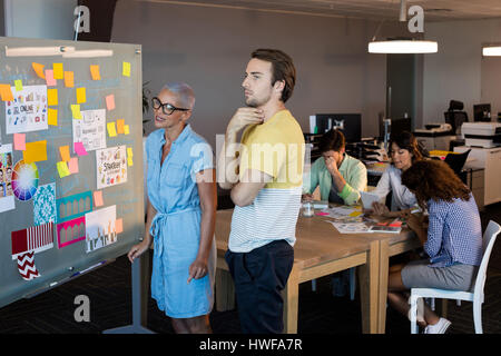 Attività creativa di persone guardando sticky notes sul bordo del vetro Foto Stock