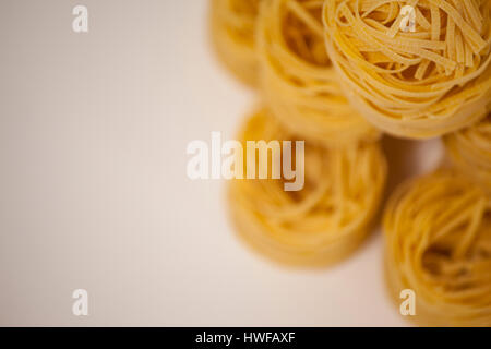 Tagliatelle disposti in una fila su sfondo bianco Foto Stock