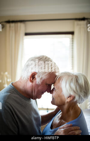 Coppia senior romancing in camera da letto a casa Foto Stock