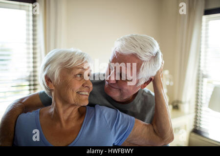 Coppia senior romancing in camera da letto a casa Foto Stock