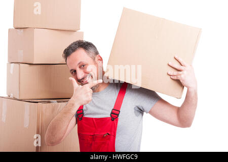 Mover uomo che indossa rosso azienda globale e puntando una grande scatola di cartone e sorridente isolati su sfondo bianco Foto Stock