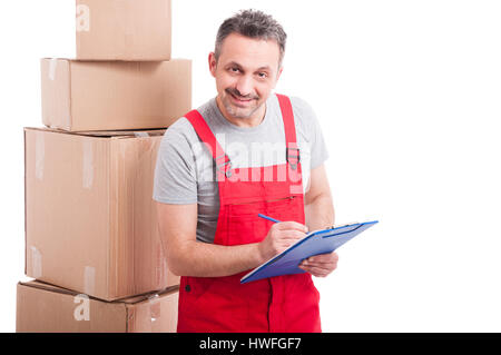 Mover guy sorridendo il conteggio o la scrittura su appunti con scatole di cartone attorno isolati su sfondo bianco Foto Stock