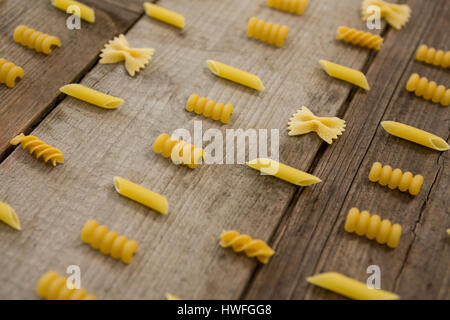 Varie pasta disposte in fila su una superficie di legno Foto Stock