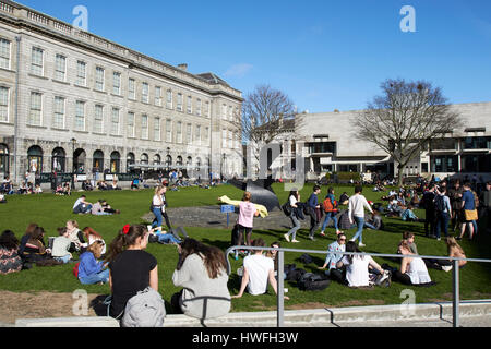 Gli studenti seduti intorno al sole sulla piazza di borsisti trinity college a Dublino Repubblica di Irlanda Foto Stock