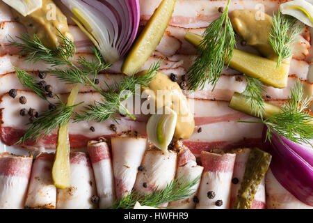 Fette di pancetta e cetrioli sottaceto sulla piastra. Foto Stock