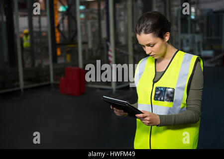 Fiducioso lavoratrice utilizzando tablet pc in magazzino Foto Stock