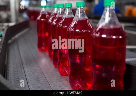 Riempito di succo rosso bottiglie sulla linea di produzione in fabbrica Foto Stock