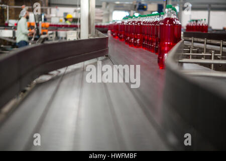 Succo rosso bottiglie sulla linea di produzione nell'industria manifatturiera Foto Stock