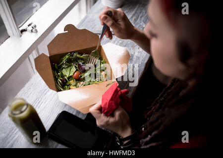 Bella donna avente una insalata in cafÃƒÂ© Foto Stock
