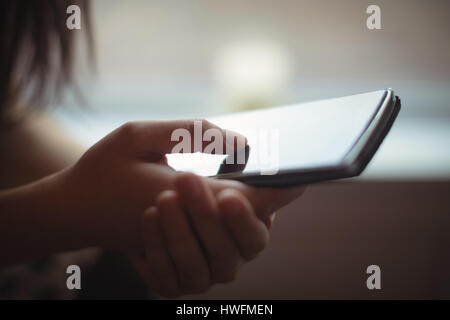 La sezione centrale della donna che utilizza un telefono mobile in cafÃƒÂ© Foto Stock