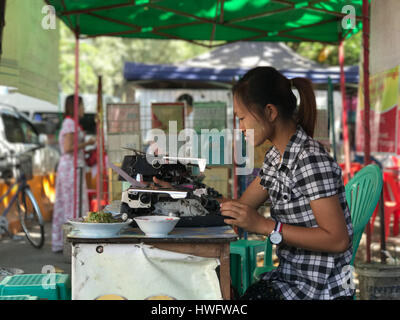 Yangon, Myanmar. Xx Febbraio 2017. Una giovane donna lavora alla sua macchina da scrivere a Yangon, Myanmar, 20 febbraio 2017. Nel "distretto notarile', circa due dozzine di uomini e donne di compilare i documenti ufficiali per i loro clienti su vecchie macchine da scrivere - soprattutto tedeschi-fabbricato. Il business sta morendo come computer e smartphone attecchire anche qui. Foto: Christoph Sator/dpa/Alamy Live News Foto Stock