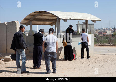 Palestinesi e soldato al Checkpoint della barriera di separazione israeliano nei territori occupati Cisgiordania Medio Oriente Foto Stock