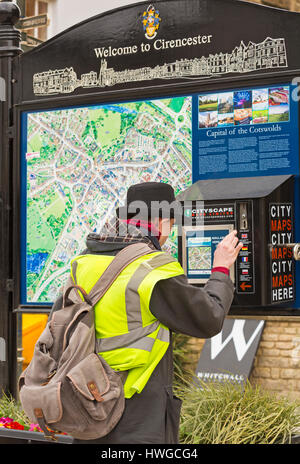 Cirencester - Uomo mettere il denaro in macchina per ottenere una mappa della città in luogo di mercato,, Cirencester Gloucestershire in Marzo Foto Stock