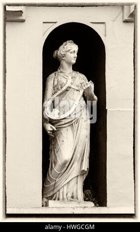 Cirencester - Statua di donna con la cetra nell'alcova di edificio a Dollar Street,, Cirencester Gloucestershire in Marzo Foto Stock