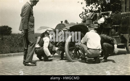 Antique c1905 fotografia, un gruppo di uomini cambiare un pneumatico sgonfio su un antico utilitaria auto. Posizione sconosciuta, probabilmente a New York. Vedere immagini di Alamy HWGCM4, HWGCKW e HWGCKR per visualizzazioni alternative di questa vettura. Fonte: originale stampa fotografica. Foto Stock