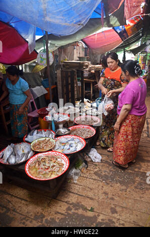 Donne comprare del pesce in un mercato coperto in Kawthaung, Myanmar Foto Stock