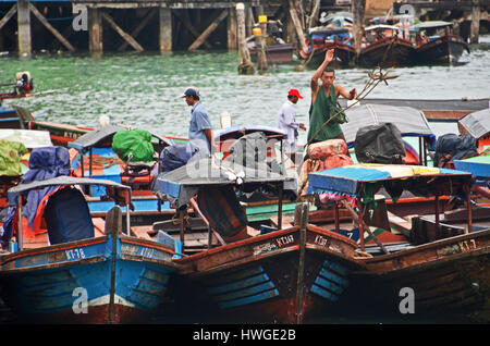 Un uomo getta una corda al dock in Kawthaung, Myanmar Foto Stock