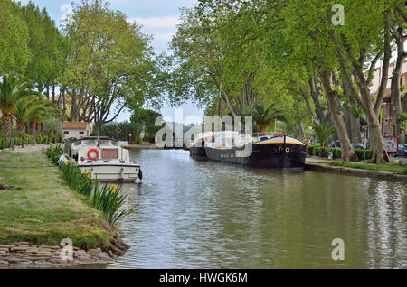 Una chiatta e un motoscafo sono ormeggiate vicino al gateway. Il Canal de Jonction corre attraverso la cittadina francese Salleles d'Aude. Questa è una parte della La Nouv Foto Stock