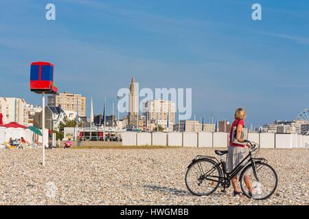 Francia, Seine Maritime Le Havre, il ciclista sulla spiaggia di ciottoli con in fondo il campanile della chiesa di San Giuseppe Foto Stock