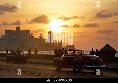 Cuba, La Habana, Malecon, vecchia vettura americana e degli scuotipaglia dal tramonto waterfront Foto Stock