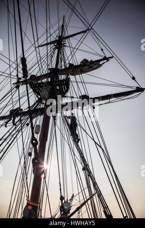 Una silhouette vista di Lady Washington equipaggio arrampicata corda Foto Stock